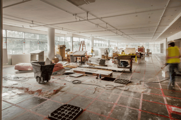 A post-construction site with scattered debris and tools, showing ongoing cleanup work.