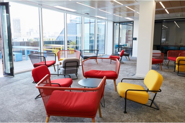 Colorful office lounge with red and yellow chairs.