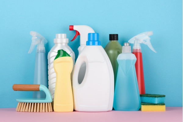 Cleaning products with brush and sponges on blue background.