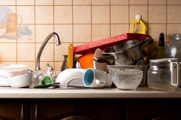 Cluttered kitchen counter with dirty dishes near sink.