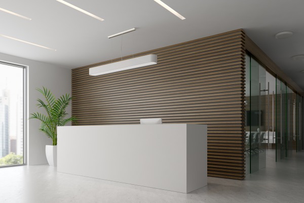 Modern office reception with wooden wall and white desk.